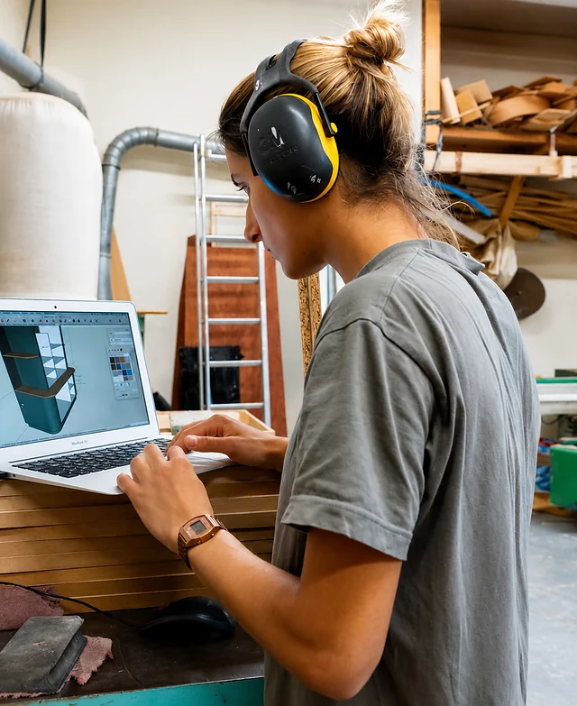 Modélisation 3D d'un meuble sur ordinateur portable, à l'atelier.