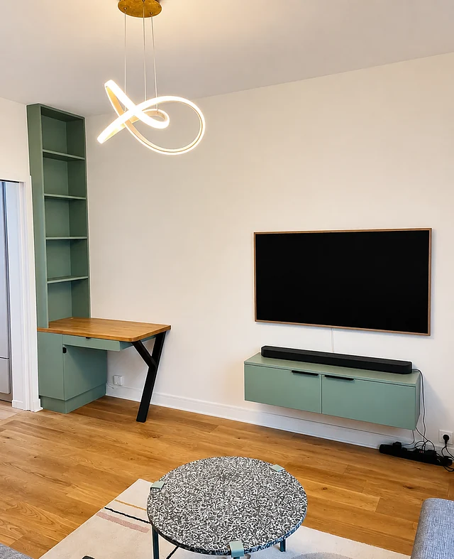 Bureau escamotable en chêne sur colonne vert d'eau, avec meuble TV suspendu assorti.