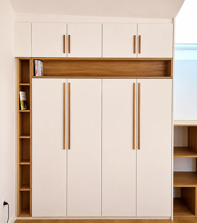 Dressing toute hauteur en laque mate crème avec bibliothèque latérale en chêne et longues poignées bâton.